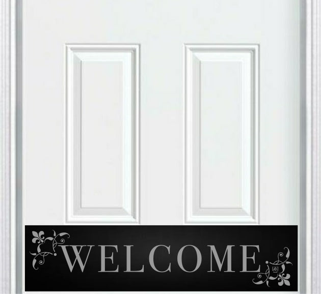 White door with a black 'WELCOME' kick plate featuring decorative elements.
