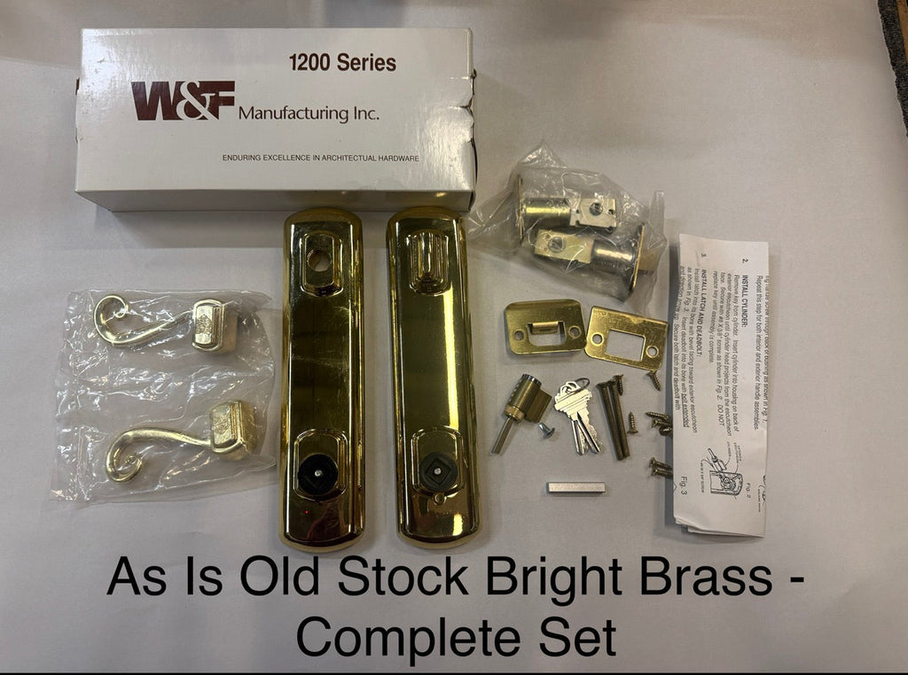 Complete set of old stock bright brass door hardware with W & F Manufacturing Inc. packaging. Handle set is bright brass with weather shield log on levers. 1200 series 6 inch center to center bore on a white background. Works on Hurd, weather shield and Peachtree doors 